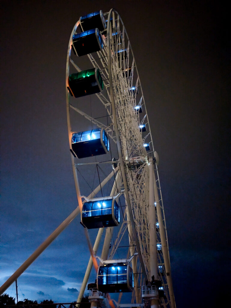 Large ferris wheel lit up at night