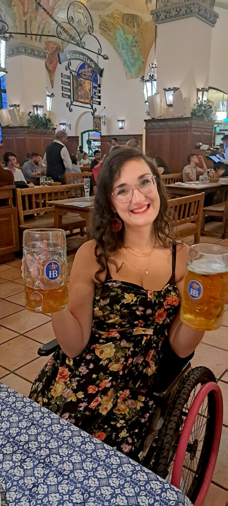 Georgina with two beer steins in the accessible beer hall in Munich