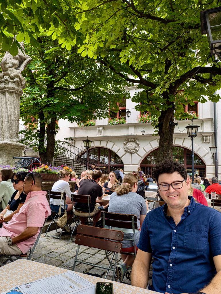 Richard, white brunette male, seated outside in the courtyard