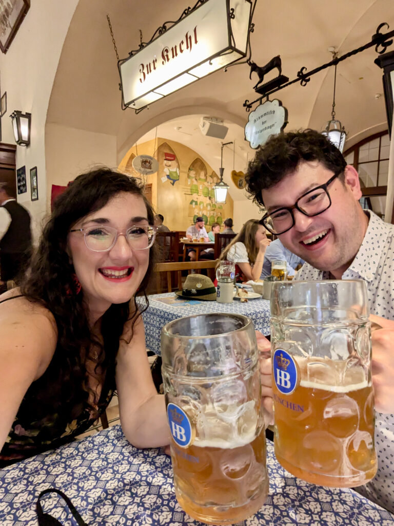 Georgina and Richard inside Hofbrǎuhaus with glass steins