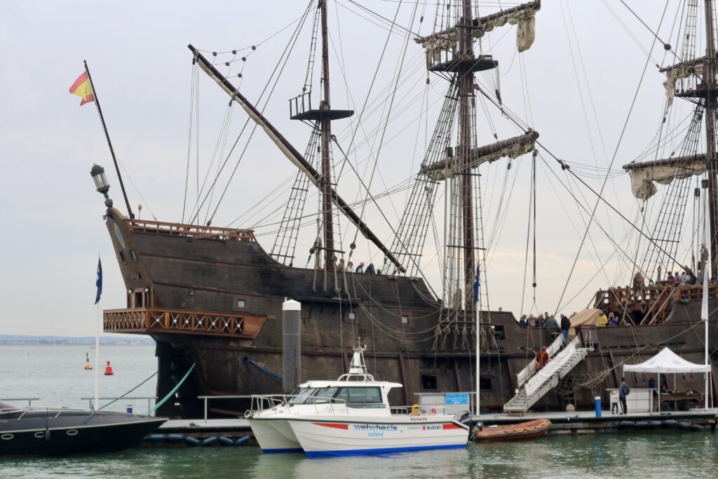 Andalucia Galeon ship with Wetwheels accessible sailing catamaran docked side by side on the Isle of Wight