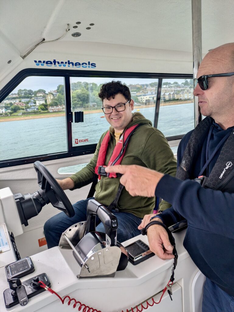 Richard, a white brunette male, driving the sailing boat as captain