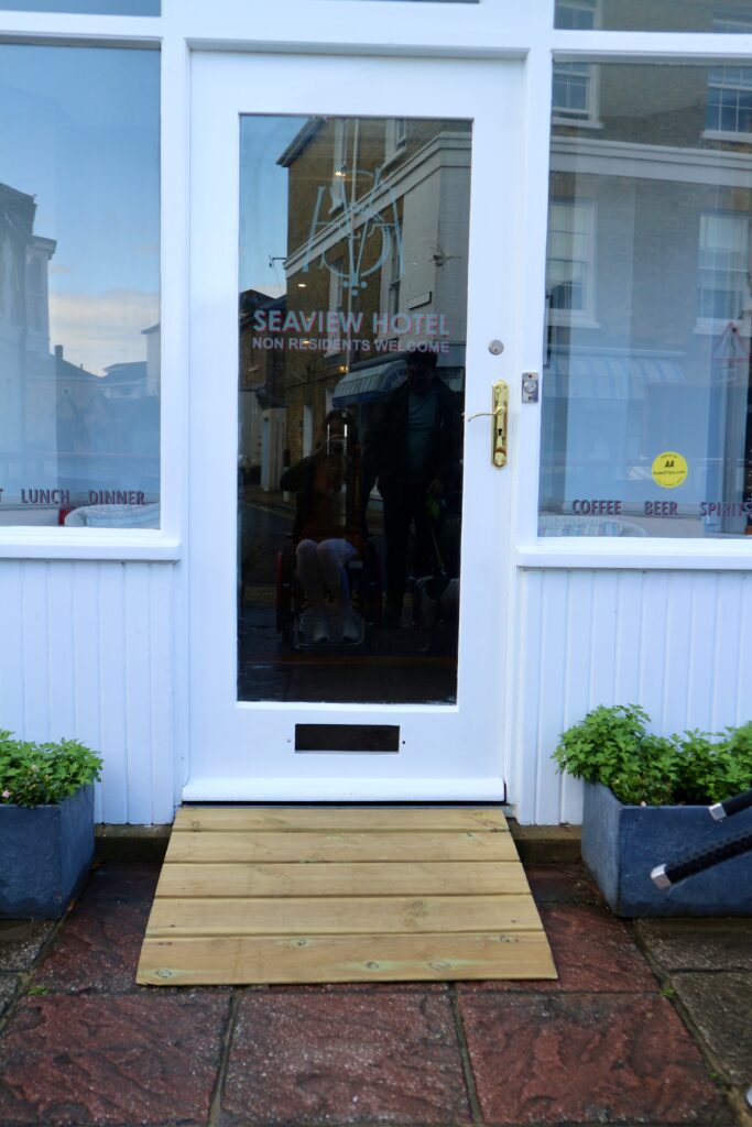 Wooden ramp to white hotel front door