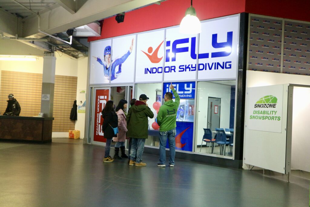iFly store front with large blue, white and red light up sign